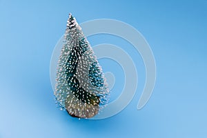 Christmas tree on pastel blue background. Christmas or New Year concept. Minimal design