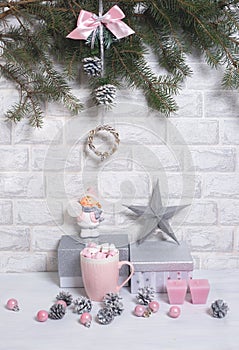 Christmas Tree Pine Branches with silver gifts, pink cup, star, candles, cones and balls and Christmas toy on a light vertical