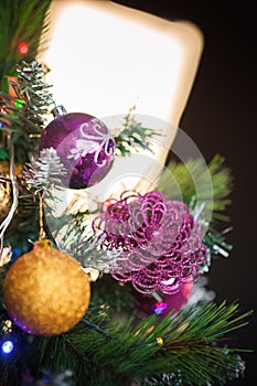 Christmas tree with purple flower toy close-up. Scandinavian style bedroom interior under Christmas. Rustic Textured Wooden Bed