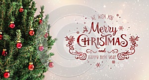 Christmas tree with red decorations and text Merry Christmas on holiday background with snow, blurred