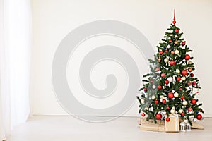 Christmas tree with red gifts in the white room Christmas