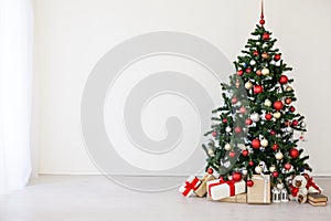 Christmas tree with red gifts in the white room Christmas