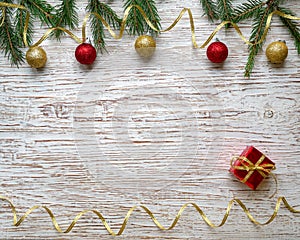 Christmas tree, balls, gift, serpentine on an old light wooden background. New Year holiday