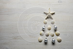 Christmas tree from sea shells and starfish on blue background, top view