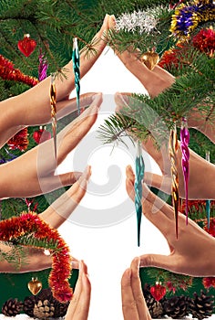 Christmas tree shape made by hands and framed with decorated fir branches and ornaments