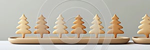 Christmas tree shaped cookies in warm tones arranged on a wooden tray against a soft neutral background photo