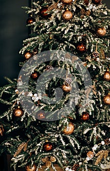 Christmas tree with shiny baubles in living room.