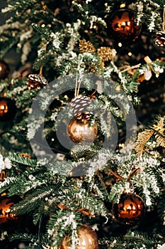 Christmas tree with shiny baubles in living room.