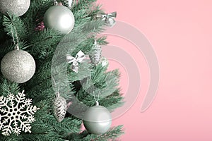 Christmas tree with silver balls on pink background. Christmas card with white silver decor