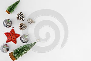 Christmas tree, silver balls, red star and pine cone on white background.