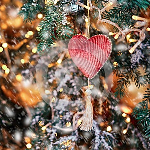 Christmas tree snow branch with red heart, close-up. New Year love or