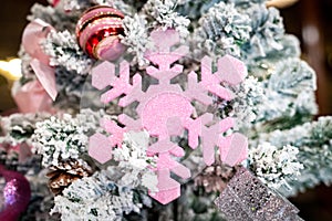 Christmas Tree with snowflake is decored with ball, presents and gift in pink theme for Christmas and new year event