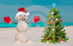 Christmas tree and snowman on the beach. Decorated pine or fir tree. Merry Christmas celebration party.