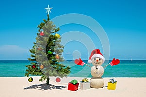 Christmas Tree and Snowman on the beach. Sandy Snowman. Merry Christmas. Happy New Year. Winter Holidays.