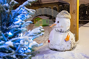 Christmas tree and snowman outdoor at snowy night