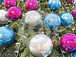 Christmas tree sparkles with garland lights, Decorated with silver, blue and pink ornaments, close-up