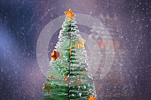 Christmas tree with stars from citrus pills on the snowfall background. Happy new year.