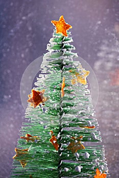 Christmas tree with stars from citrus pills on the snowfall background. Happy new year. Vertical foto.