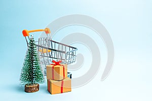 Christmas tree, supermarket cart and gift on a blue background. Minimalism. Family holiday, Christmas and New Year. Sale of gifts