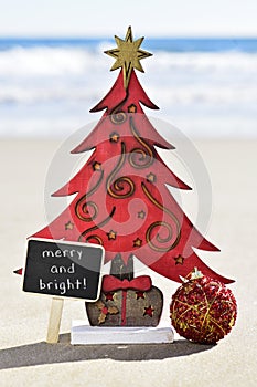 Christmas tree and text merry and bright on the beach