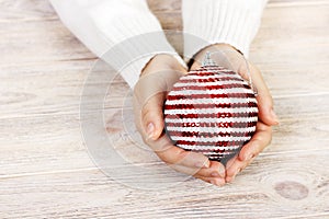 Christmas tree toy in the hands of a women. New Year. Christmas. Wooden Background