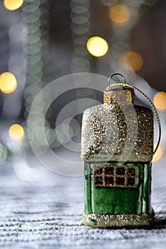 Christmas tree toy in the shape of a house against the background of a bokeh