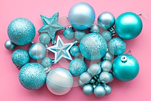 Christmas tree toys background. Blue balls and stars on pink background top view