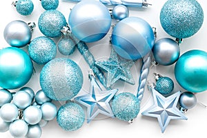 Christmas tree toys background. Blue balls and stars on white background top view