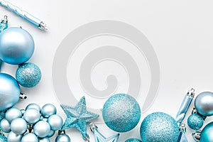 Christmas tree toys background. Blue balls and stars on white background top view copy space border