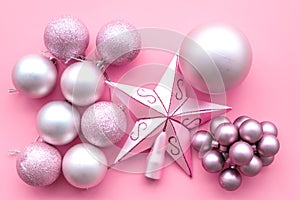 Christmas tree toys background. Pink balls and stars on oink background top view