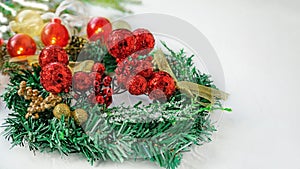 Christmas tree toys red berry balls hanging on Christmas tree on light background with ribbon from Christmas tree. Copy space,