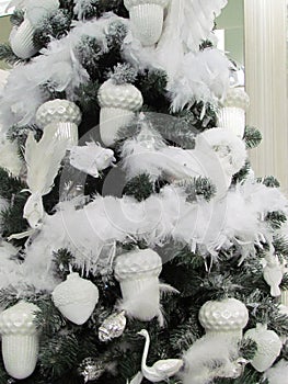 Christmas tree with only white decorations, birds, glands, swans, feathers and snow