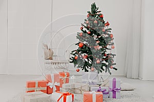 Christmas tree in white interior with stocking-stuffers