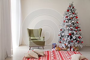 Christmas tree in a white room with gifts in the winter