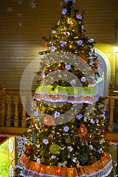 Christmas tree in a wooden house.Christmas tree decorated with lights