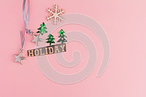 Christmas trees, toy stars, snowflake and Holiday lettering inscription on a pink background. Winter Holiday festive greeting gift