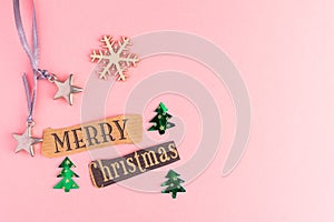 Christmas trees, toy stars, snowflake and Merry Christmas lettering inscription on a pink background. Winter Holiday festive