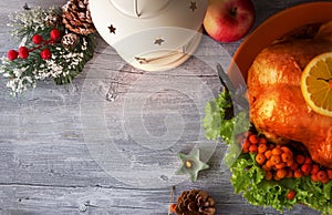 Christmas Turkey with festive lantern, berries and cones on wooden background