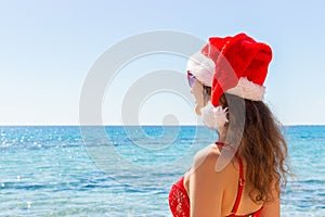 Christmas vacation paradise holiday. woman joy and success enjoying sun travel getaway with santa hat