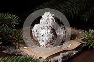 Christmas vegan balls with dates, peanut butter and coconut on dark moody background