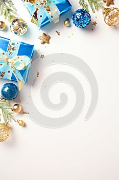 Christmas vertical banner with blue and gold baubles, gift boxes, star ornaments and confetti isolated on white background with