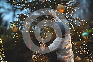 Christmas vintage background with boy, Christmas tree, and light bulbs.