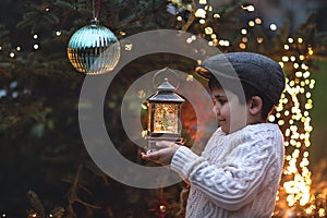 Christmas vintage background with boy, Christmas tree, and light bulbs.