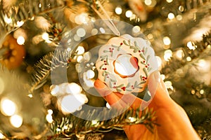 Christmas vintage toys. Christmas white decorative donut in hand in sunlight on Christmas tree background. Christmas