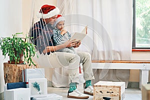 Christmas, what a special chapter. a young man reading a book with his adorable son at Christmas.