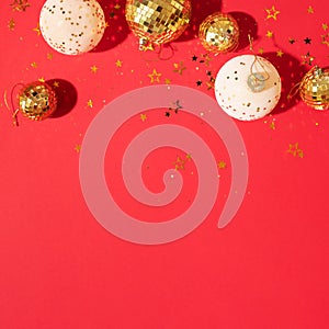 Christmas white and gold decorations, mirror disco balls, star sparkles over red background. Flat lay, top view. Minimal New year