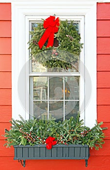 Christmas window wreath and holiday decorated window planter with red and green
