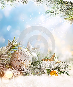 Christmas winter background with Christmas baubles and fir tree branches on snow