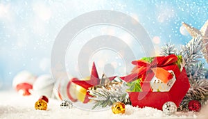 Christmas winter background with gift box, Christmas baubles and fir tree branches on snow