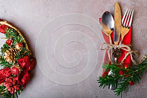 Christmas winter background from red wreath with silver place setting on stone table. Christmas and New Year holidays, copy space